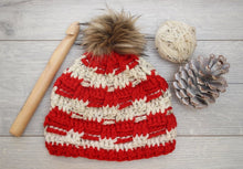 Load image into Gallery viewer, red and white beanie with a big wooden crochet hook and pine cone