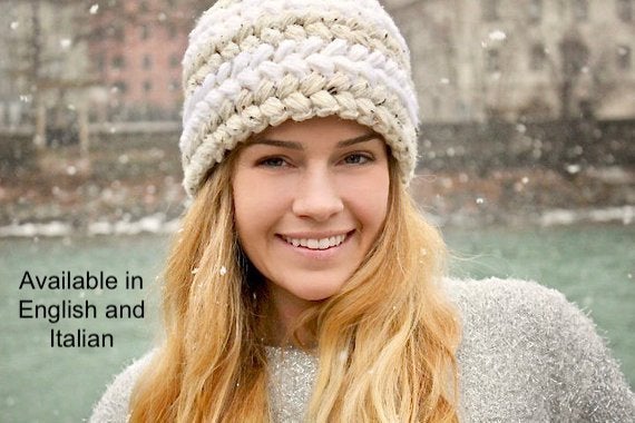 girl smiling with long blonde hair wearing a crochet hat in a winter scene