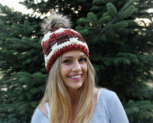 Load image into Gallery viewer, girl smiling wearing a brown beanie with a green tree behind her
