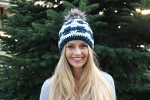 Load image into Gallery viewer, girl smiling at camera with blue beanie and green tree in background
