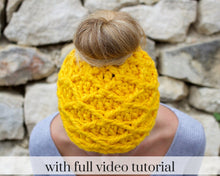 Load image into Gallery viewer, girl looking down wearing a yellow bun beanie 
