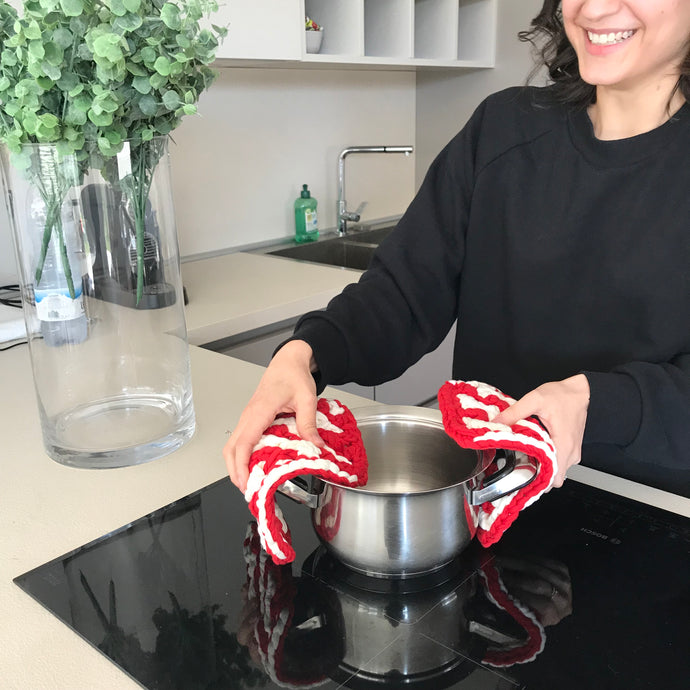 girl in kitchen using red zig zag hot pads 