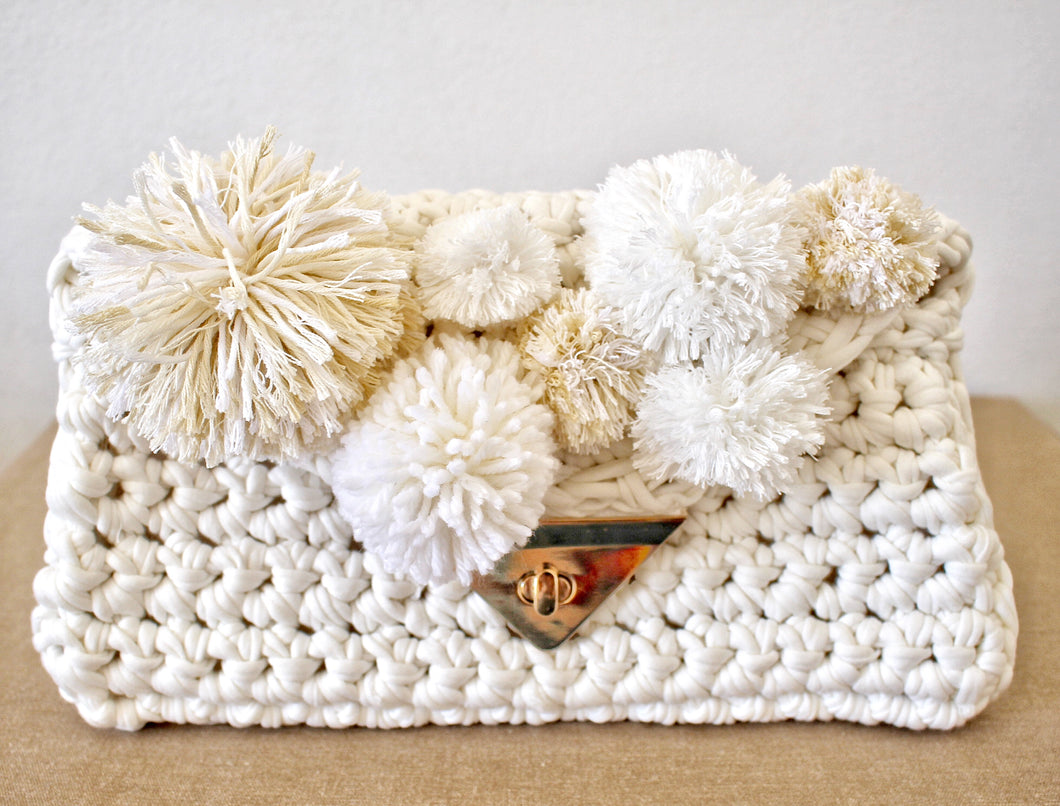 White crochet clutch with pom poms and gold clasp