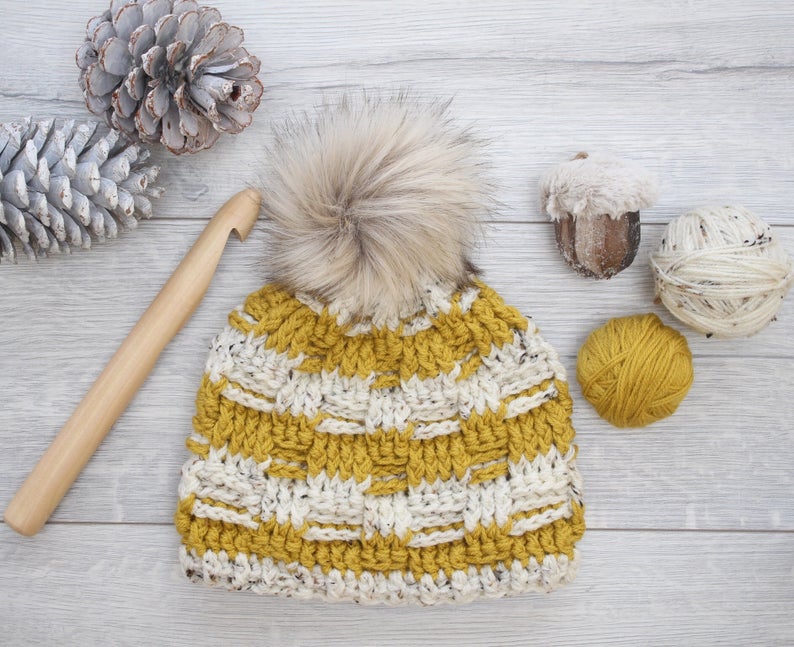 yellow crochet beanie with a furry pom pom and big crochet hook