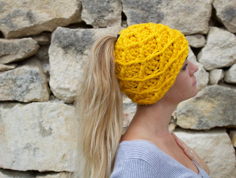 girl with long hair wearing a yellow messy bun beanie